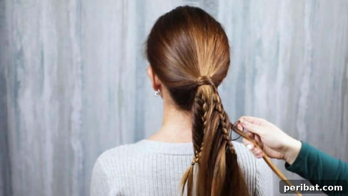 The developing fishtail braid within the ponytail, showing the woven texture