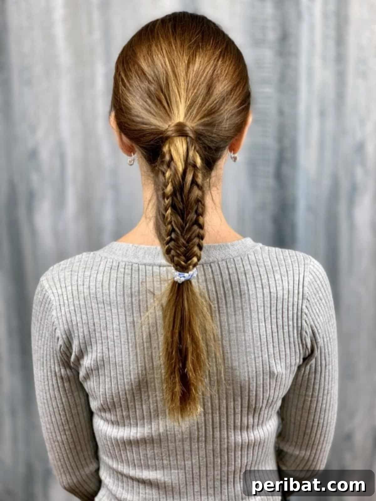 Full back view of a perfectly styled fishtail braid ponytail, showcasing the completed look
