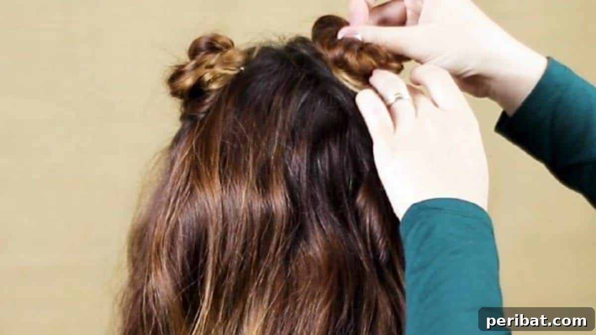 Chic Braided Twin Bun Half Updo 13 Pinning the second braid in place to complete the dual top knots