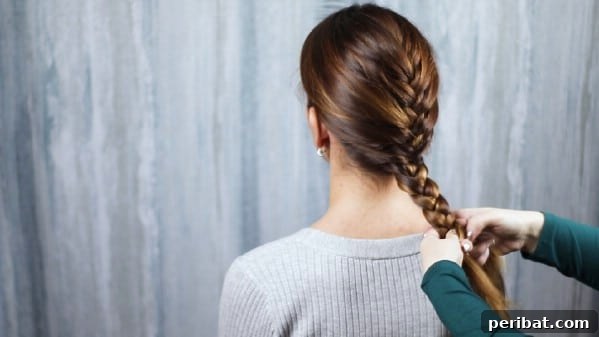 Sweet Ribbon Braid Style 8 The process of transitioning from a French braid to a simple three-strand plait, continuing the braid down the back of the head.
