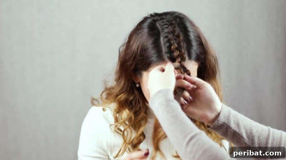 Regal Braided Crown Updo Video Steps 10 Step 3: Securing a finished side plait on the front of the head.