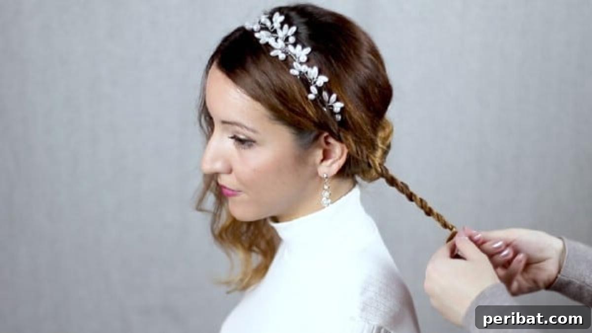 Chic Low Braided Updo Tutorial 13 Neatly braiding a small section of hair on the side, securing the end with a tiny elastic