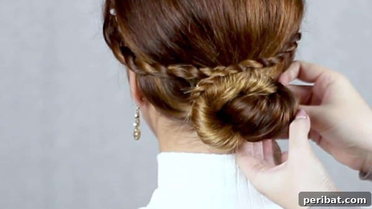 Chic Low Braided Updo Tutorial 15 Final securing of the criss-crossed braids around the low bun with bobby pins, completing the style