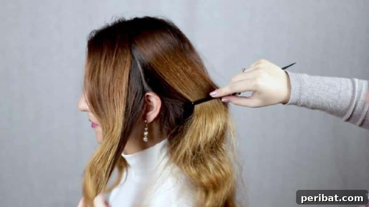 Chic Low Braided Updo Tutorial 6 Hair being parted from the front to the back in preparation for braiding and bun creation