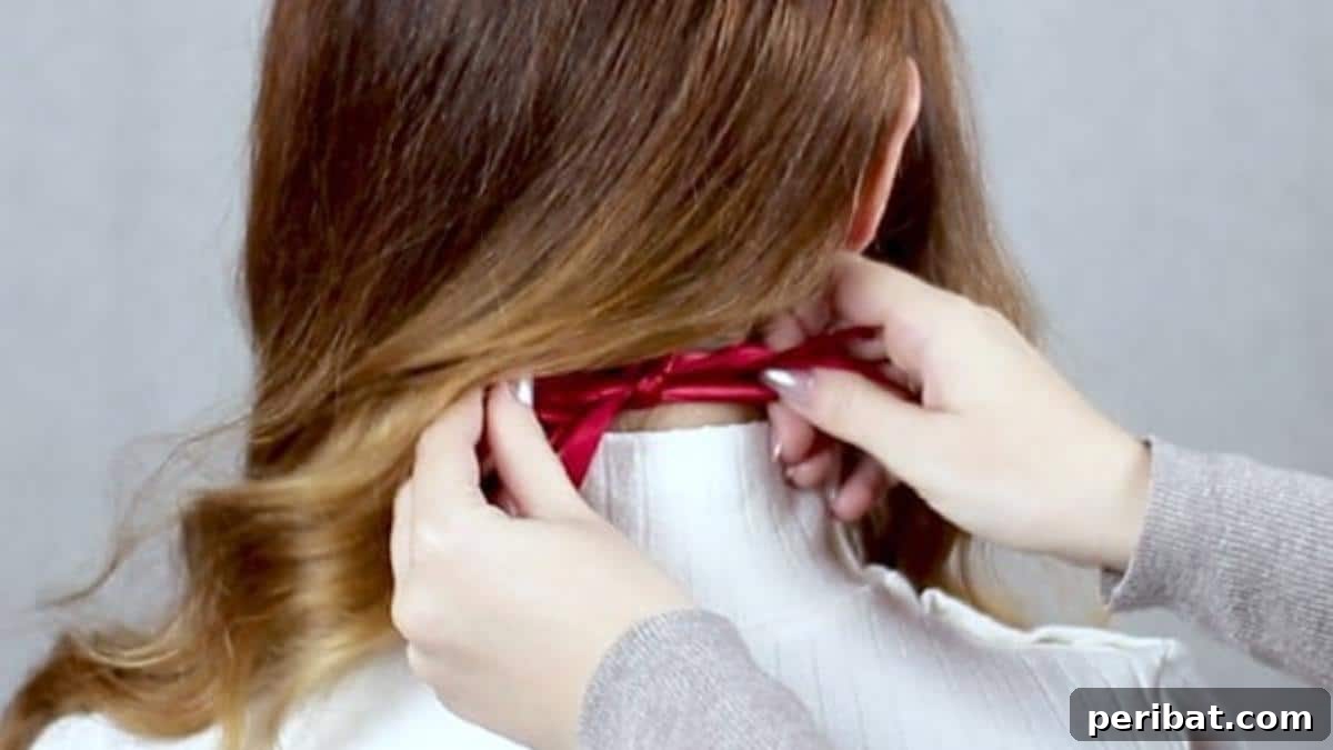 Chic Low Braided Updo Tutorial 8 Hair tie being secured discreetly behind the hair at the nape of the neck