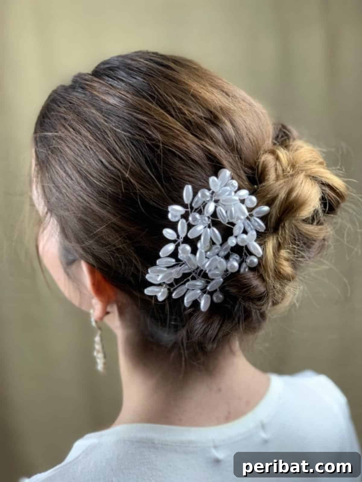 Quick and Chic Braided Messy Bun Video 17 Rear view of a brunette's head featuring a beautifully decorated and secured braided messy bun