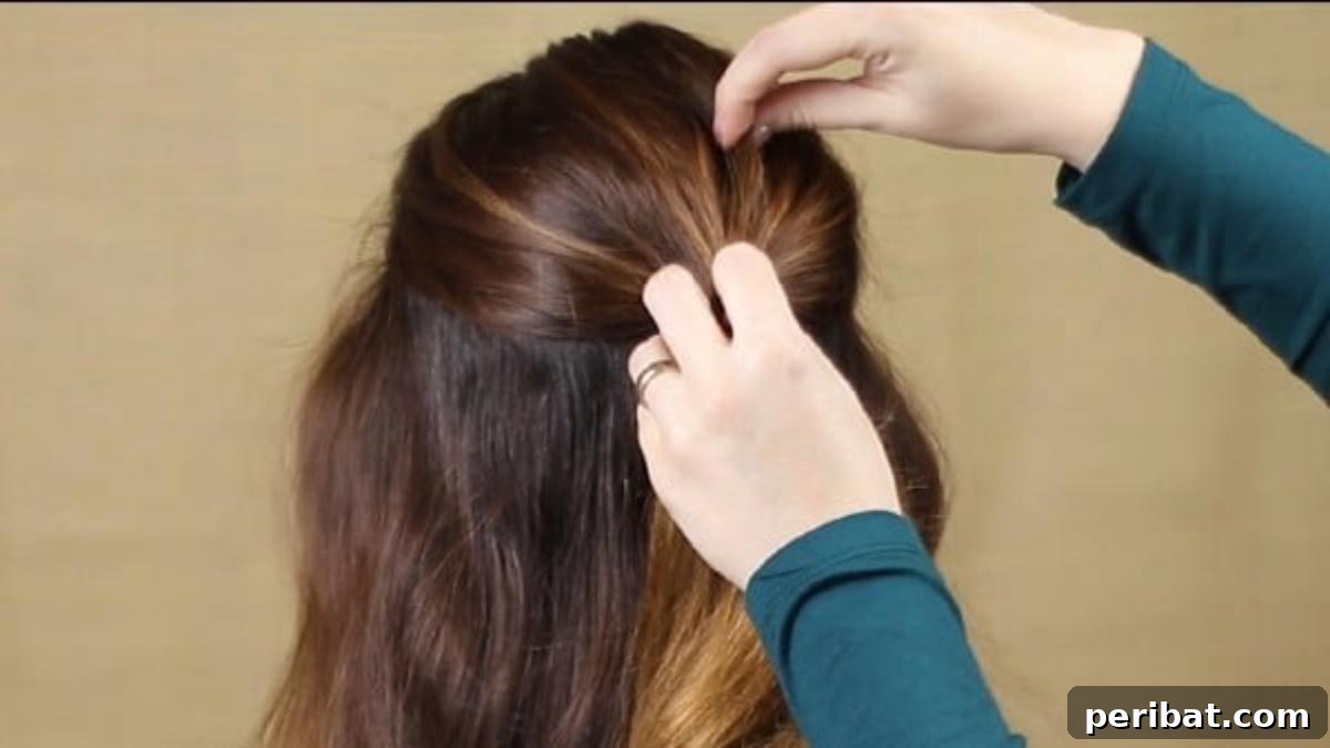 Quick and Chic Braided Messy Bun Video 5 Initial step of separating the top section of hair for volume