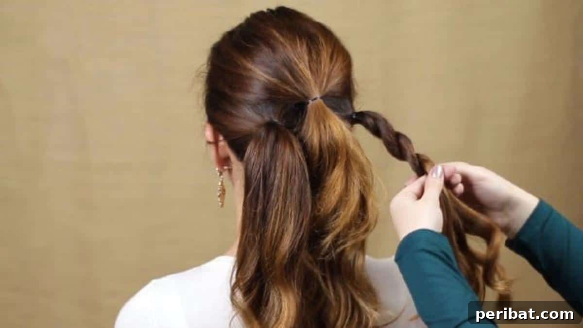 Quick and Chic Braided Messy Bun Video 8 Expertly twist braiding a ponytail for added texture and volume