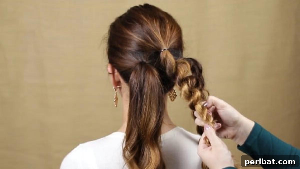 Quick and Chic Braided Messy Bun Video 10 Continuing the twist braiding and fluffing process on the middle ponytail