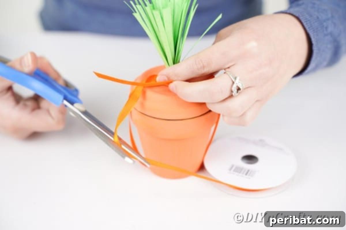 Handcrafted Easter Carrot Pots 13 Tying orange ribbon around flower pot