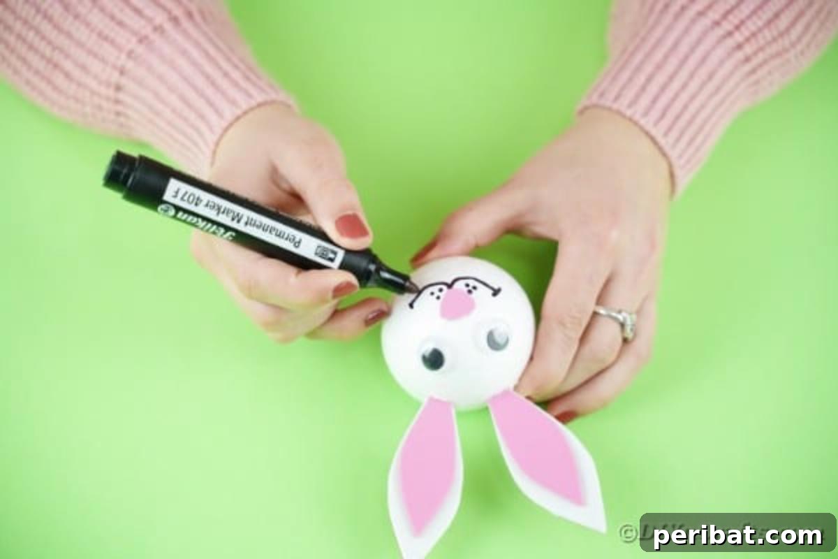 DIY Adorable Easter Bunny Wreath Video Guide 14 Drawing a smile and whiskers on the bunny's face with a black marker.