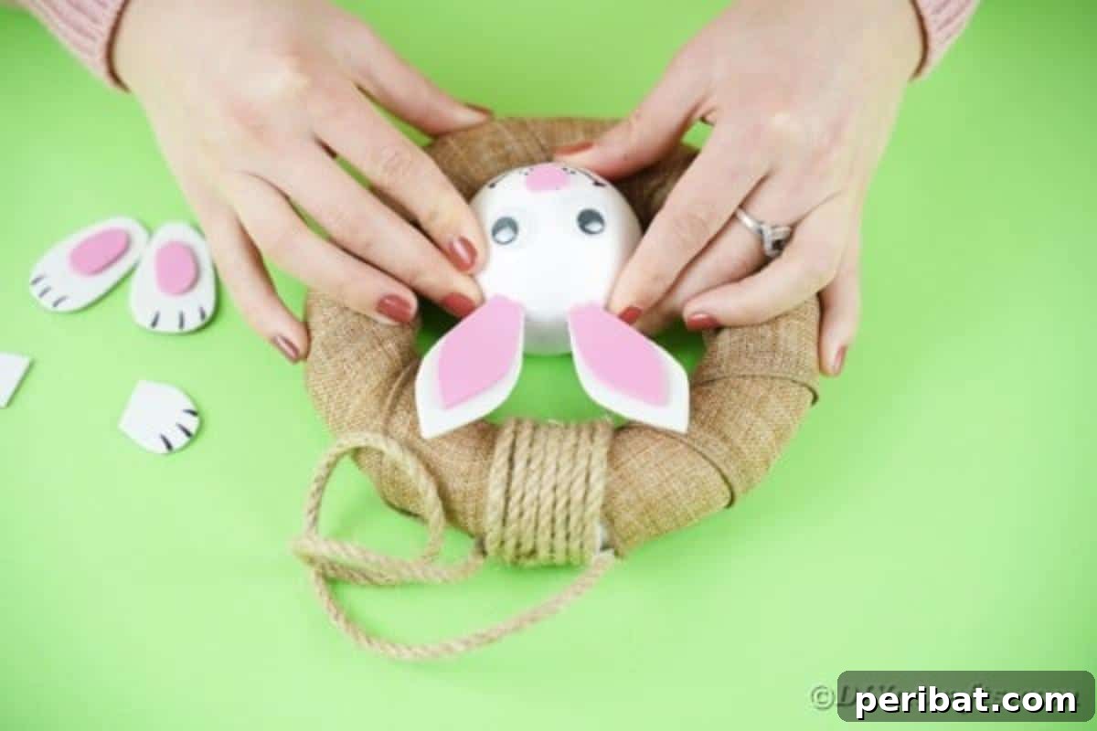DIY Adorable Easter Bunny Wreath Video Guide 15 Gluing the bunny head to the bottom inside of the burlap wreath.