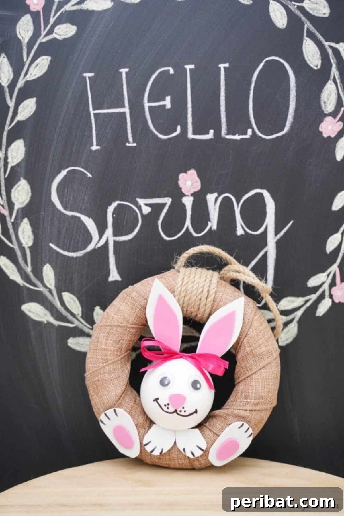 DIY Adorable Easter Bunny Wreath Video Guide 18 Completed Easter bunny wreath hanging on a chalkboard surface, ready for display.