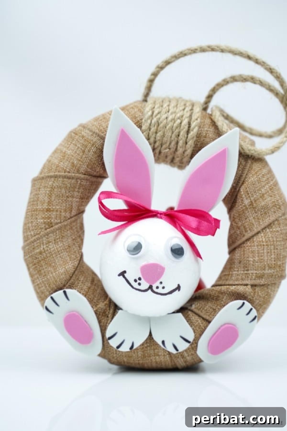 DIY Adorable Easter Bunny Wreath Video Guide 4 Handmade Easter bunny wreath with burlap and paper details, set against a plain white background.