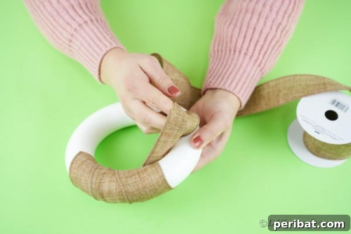 DIY Adorable Easter Bunny Wreath Video Guide 7 Wrapping a wreath form with burlap ribbon, showing the initial securement.