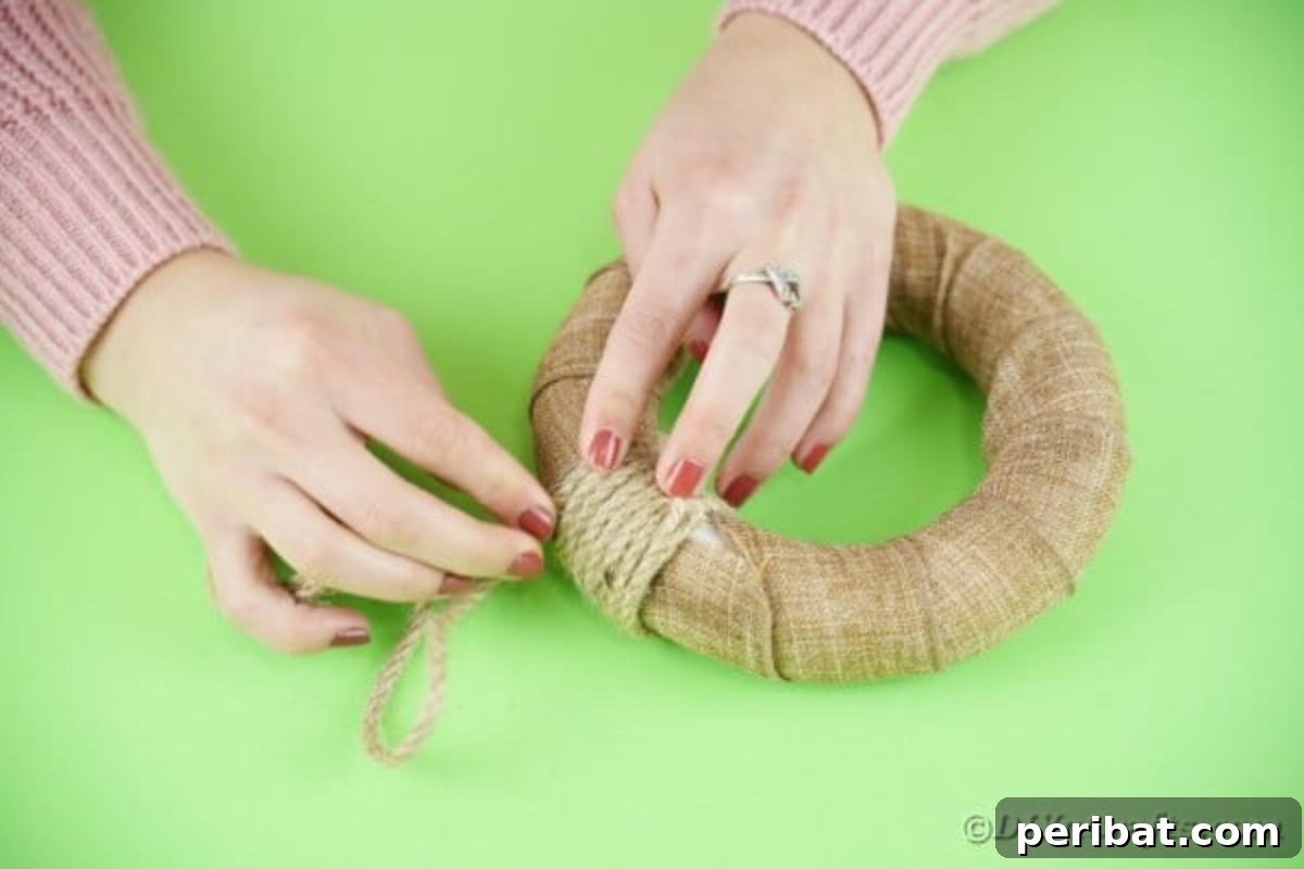 DIY Adorable Easter Bunny Wreath Video Guide 9 Wrapping rustic rope around the top of the burlap-wrapped wreath to create a hanger.