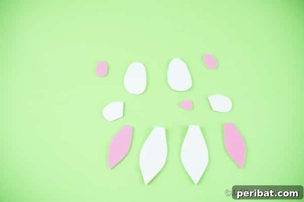 DIY Adorable Easter Bunny Wreath Video Guide 10 Cut paper shapes for bunny ears and feet in white and pink.