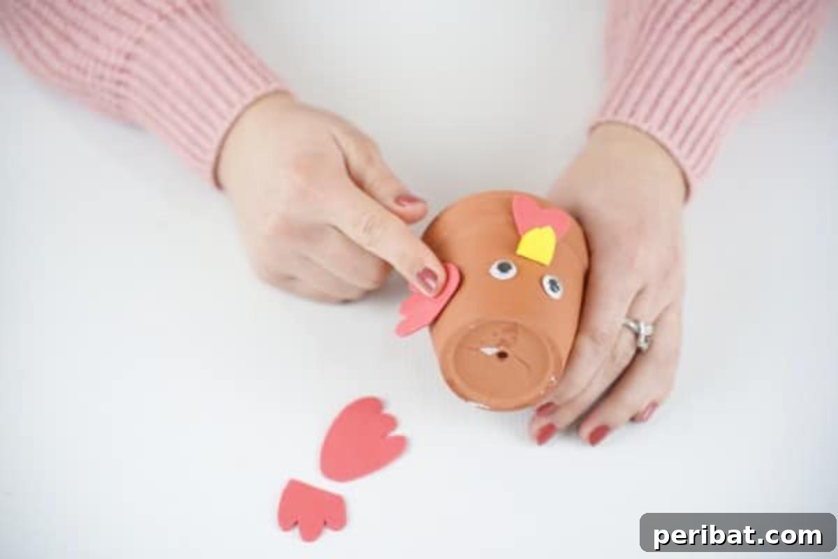Craft Your Own Cute Flower Pot Chicken 13 Gluing wings on flower pot chicke