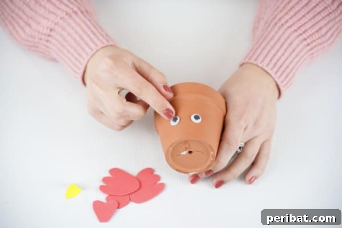 Craft Your Own Cute Flower Pot Chicken 10 Gluing googly eyes on flower pot