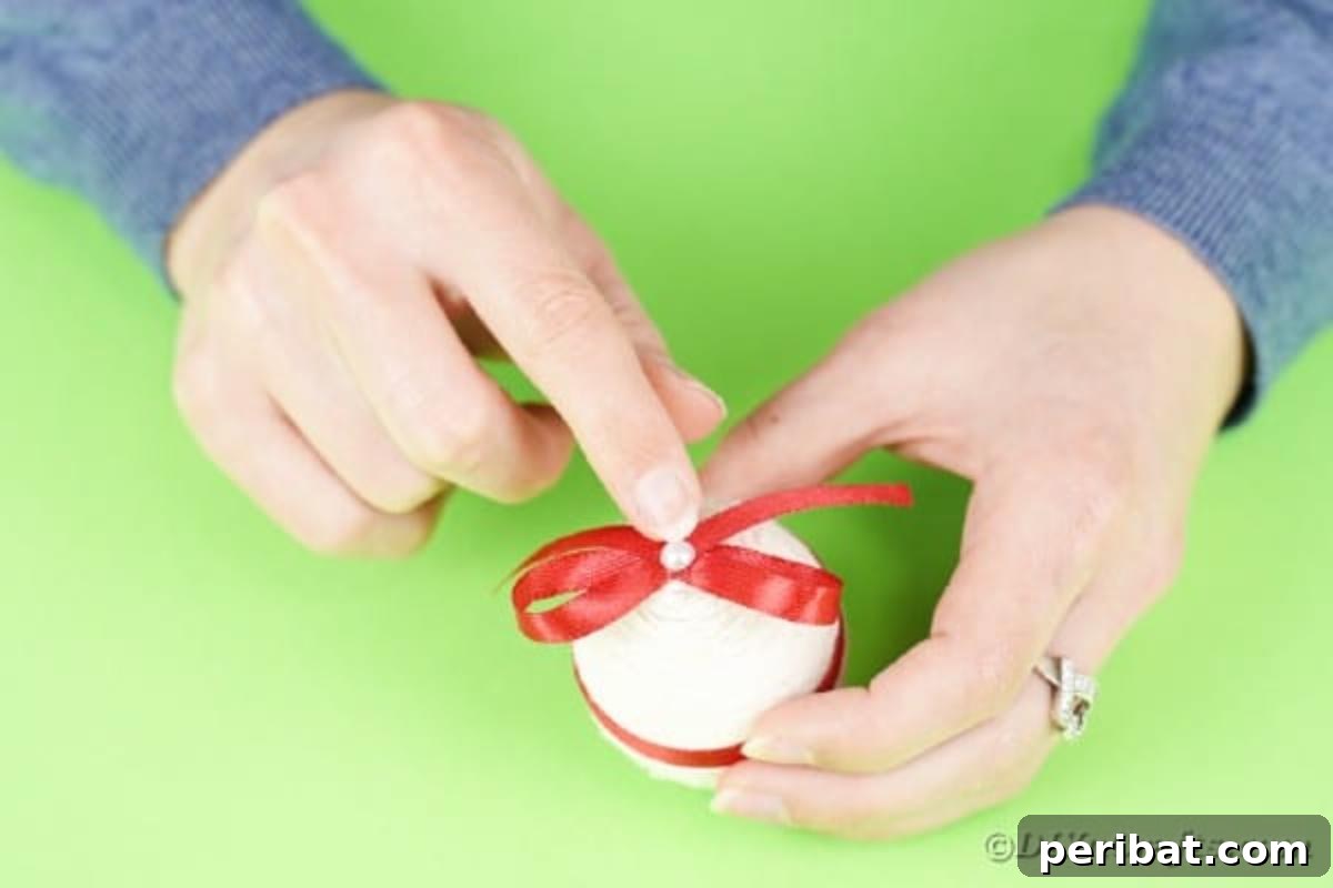 Crafting Yarn Wrapped Easter Eggs 11 Adding a small decorative element to the center of the bow on the egg