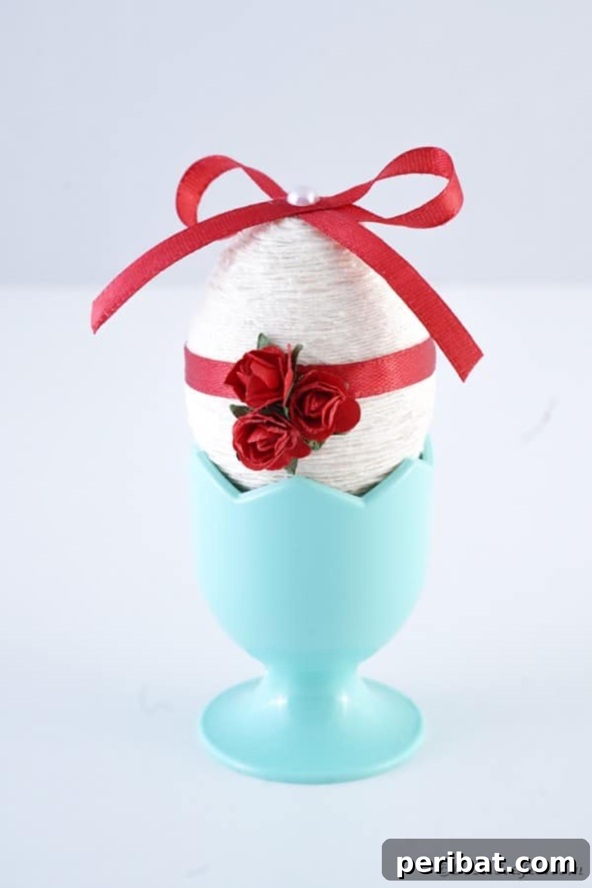 Crafting Yarn Wrapped Easter Eggs 4 Blue egg cup holding a white and red yarn wrapped Easter egg