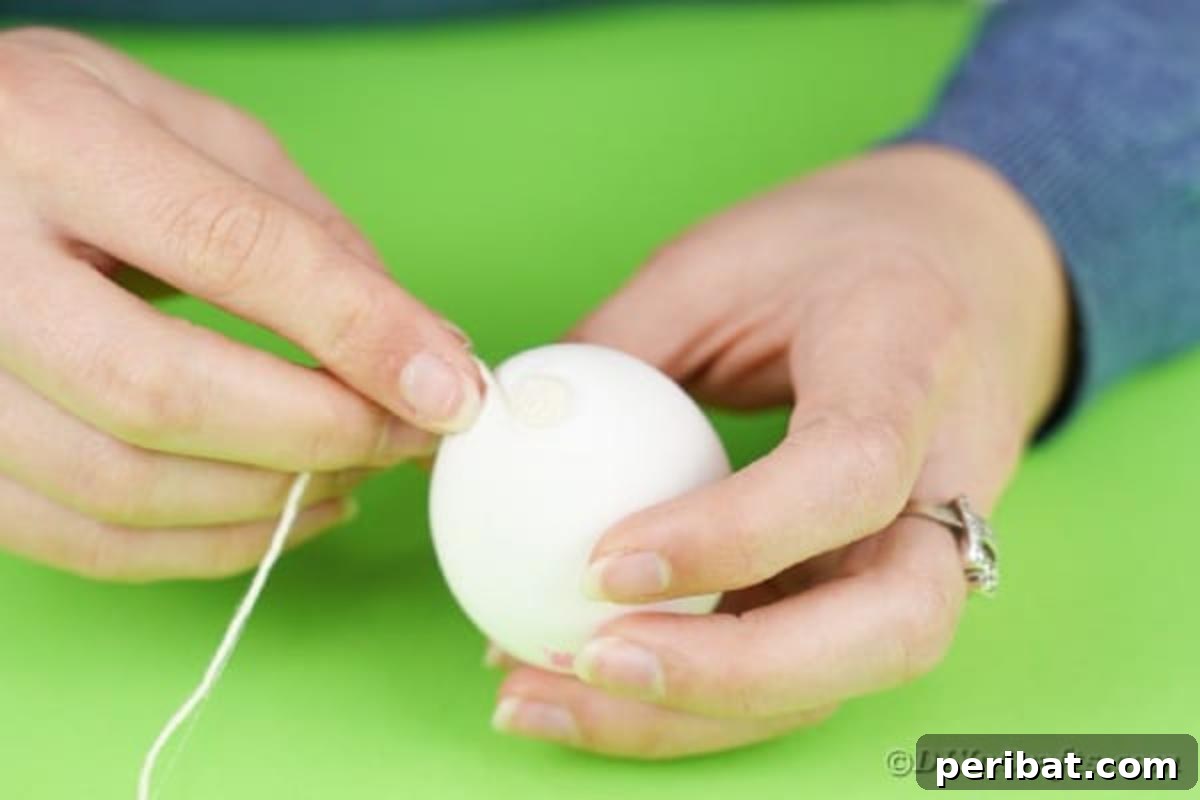 Crafting Yarn Wrapped Easter Eggs 7 Gluing the initial end of the yarn to the top of an Easter egg