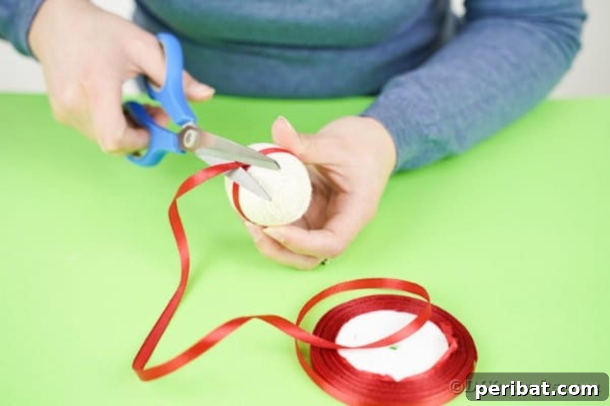 Crafting Yarn Wrapped Easter Eggs 9 Gluing the red ribbon band around the middle of the yarn wrapped egg