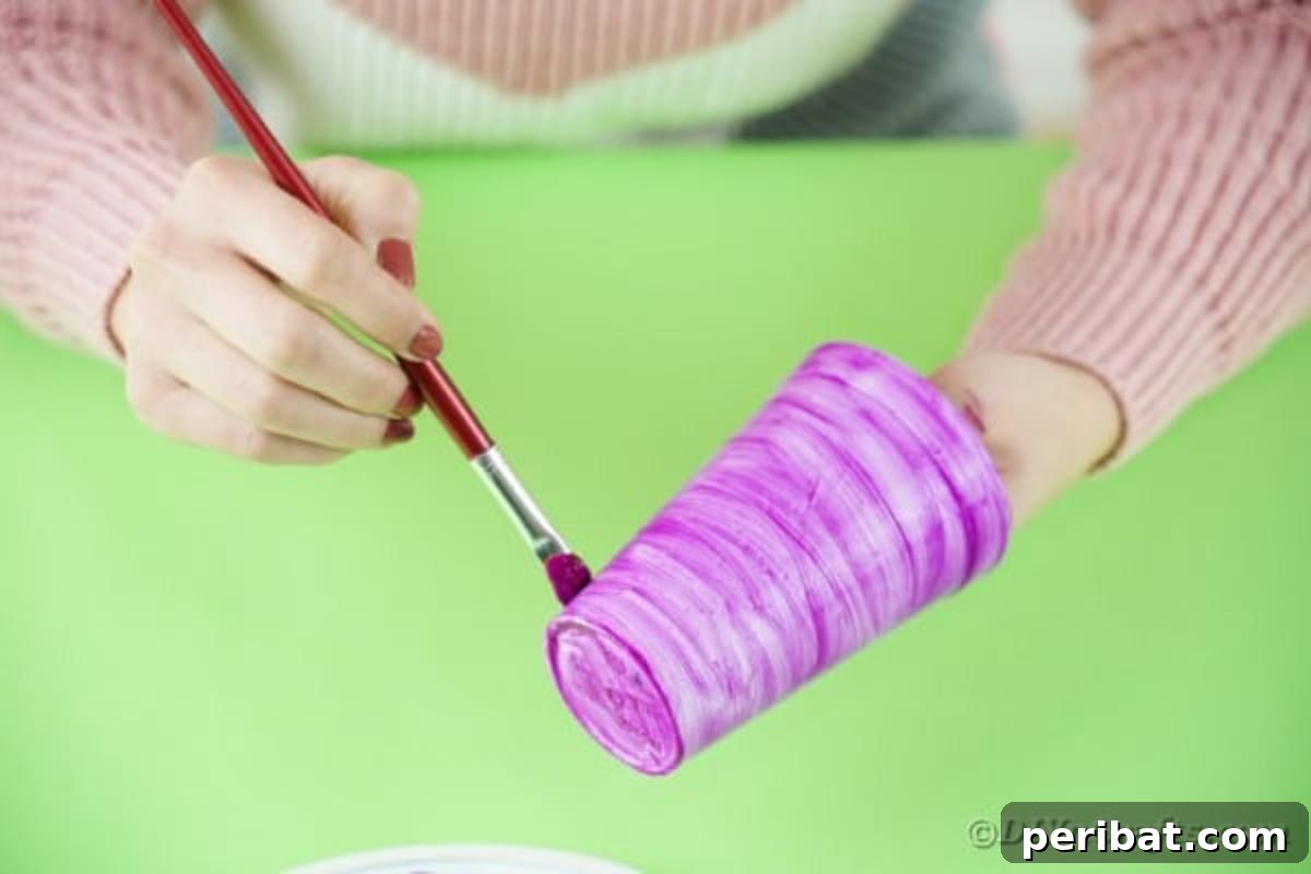 Turn Plastic Cups Into Charming Owls 7 Painting a plastic cup pink as the base for the owl craft.