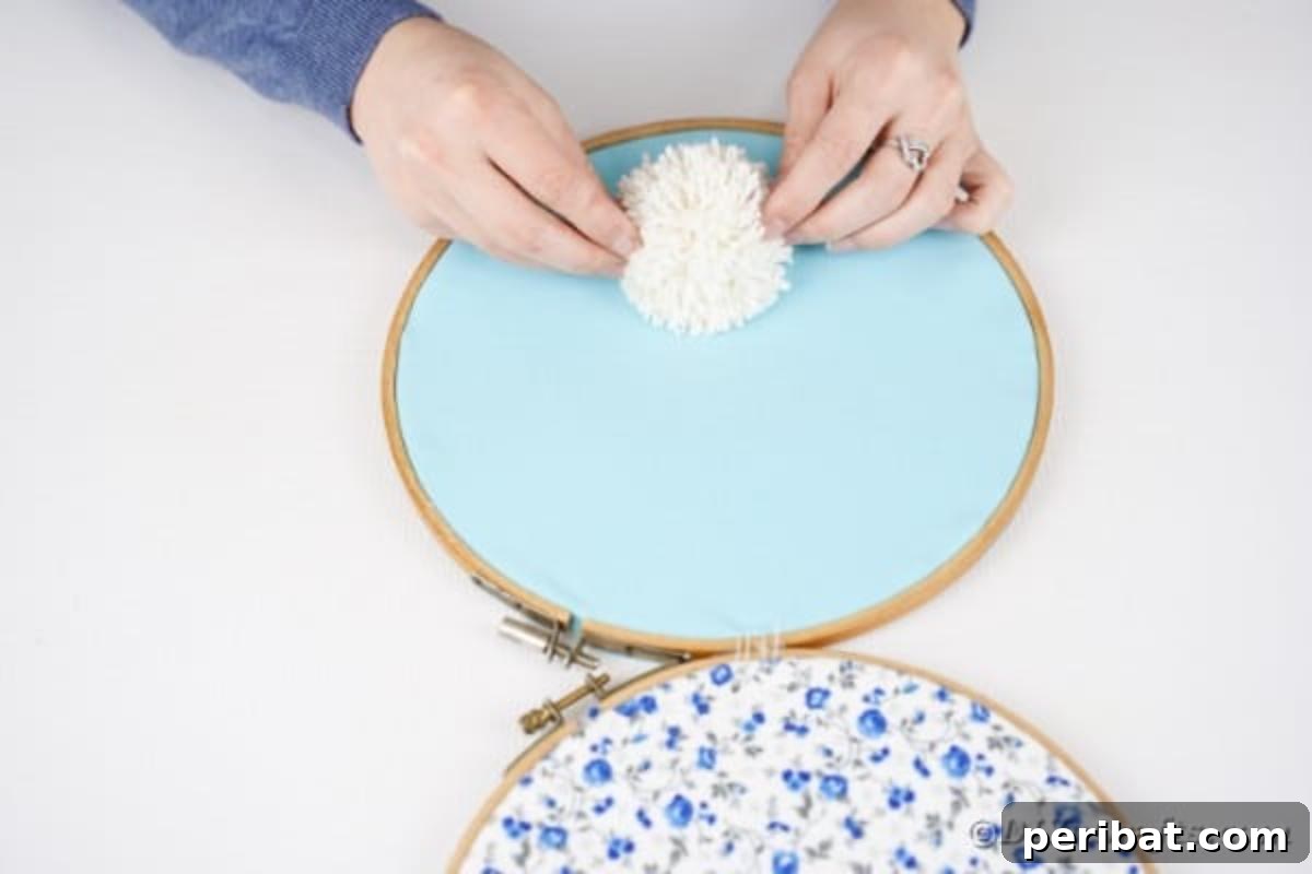 Hoppy Easter Bunny Wall Art DIY 13 Gluing the yarn pom pom onto the bottom embroidery hoop for the bunny's tail