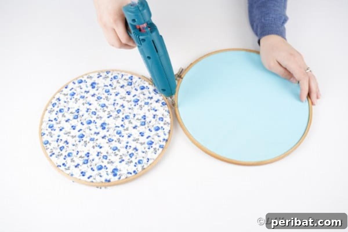 Hoppy Easter Bunny Wall Art DIY 9 Applying hot glue to join two embroidery hoops together to form a bunny shape