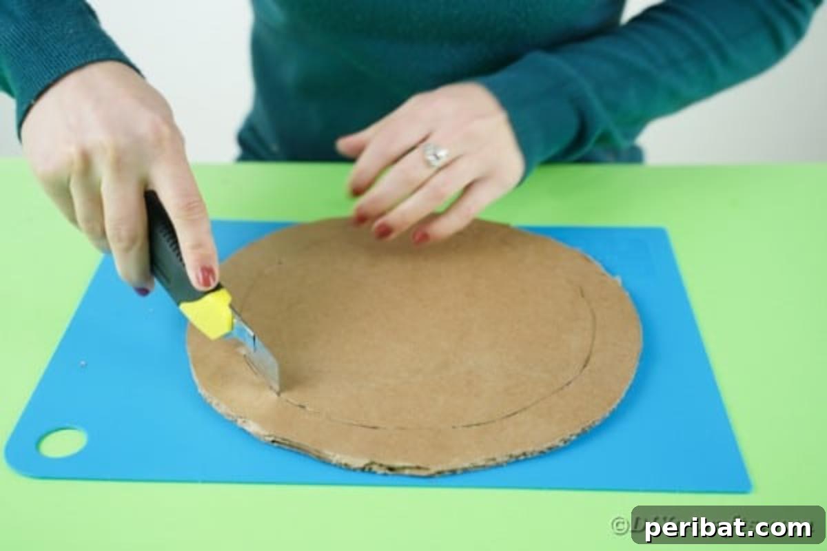 Fluffy Pom Pom Easter Bunny Door Wreath 11 Cutting a cardboard circle to create a wreath frame.