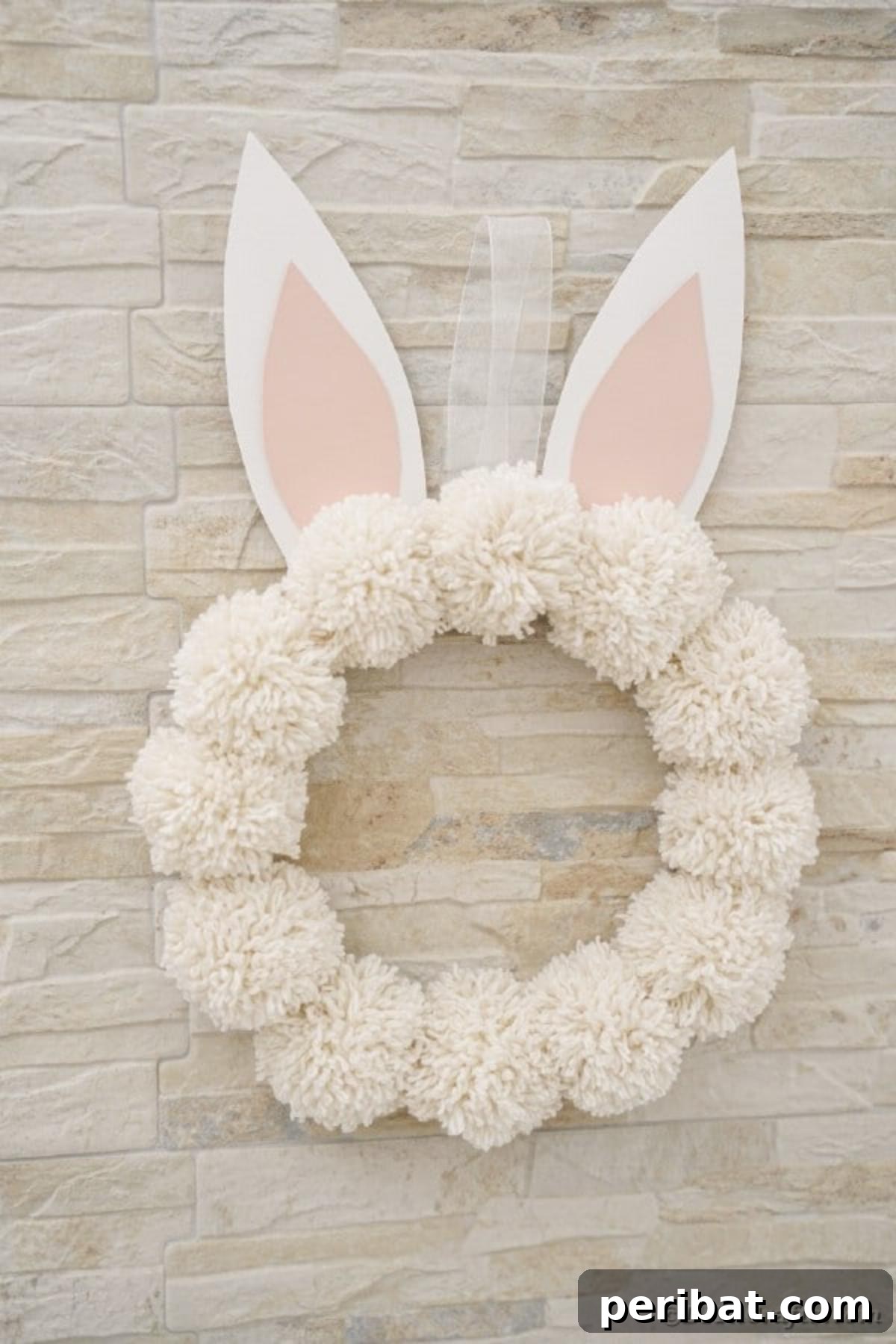 Fluffy Pom Pom Easter Bunny Door Wreath 18 Finished DIY Pom Pom Easter Bunny Wreath displayed on a door for Easter.