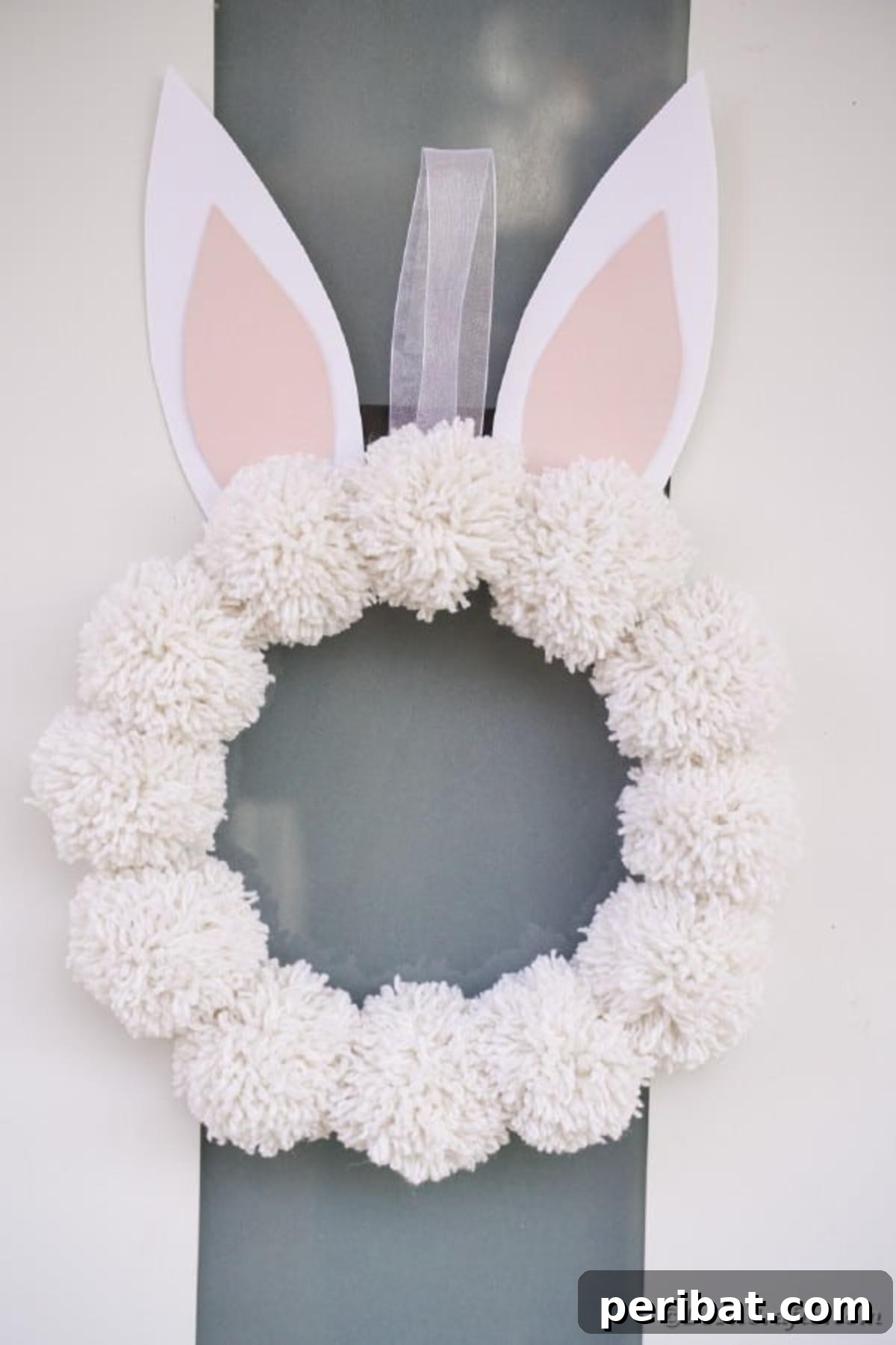 Fluffy Pom Pom Easter Bunny Door Wreath 4 Step-by-step image demonstrating how to make a pom pom for the DIY Easter Bunny Wreath.