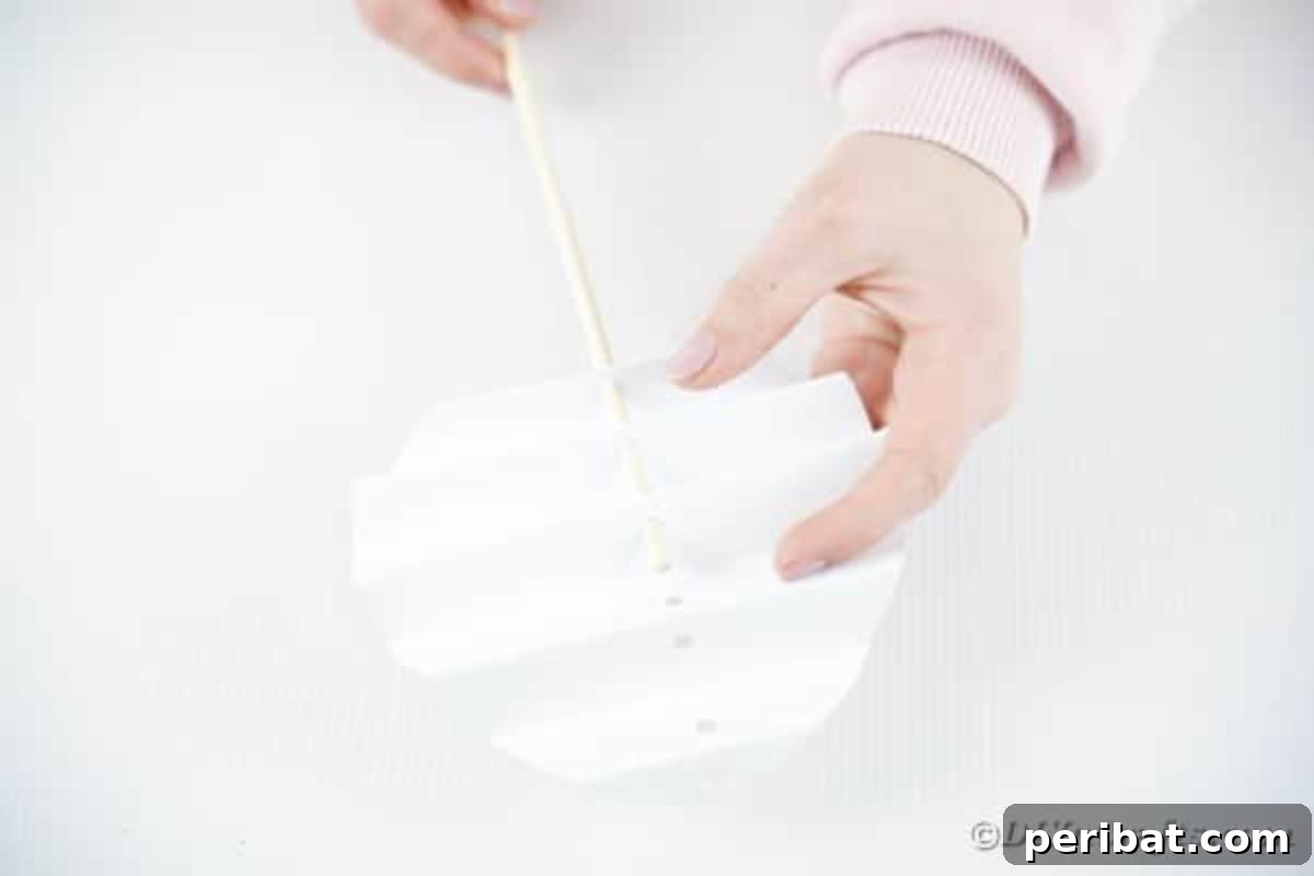DIY Easter Paper Bunny Craft Free Printable Template 13 Image depicting the dowel rod being threaded through the bunny's body