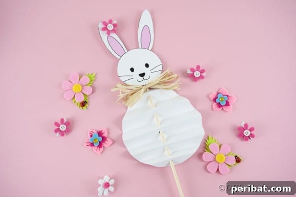 Paper Easter bunny on pink surface, showcasing the finished craft