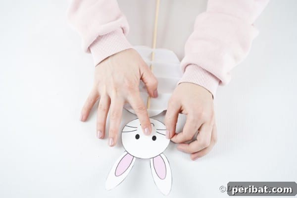 DIY Easter Paper Bunny Craft Free Printable Template 24 Gluing the bunny head to the top of the dowel rod