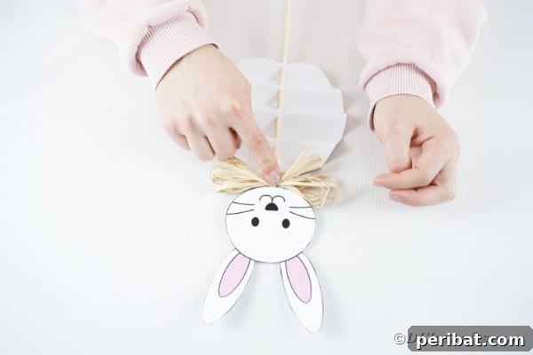 DIY Easter Paper Bunny Craft Free Printable Template 25 Gluing a twine bow to the bunny's neck area