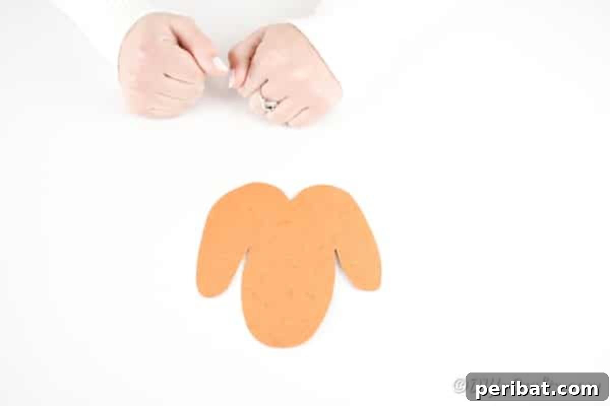 DIY Monkey Card Fun for Kids 15 A hand-drawn body shape for the paper monkey, featuring a long oval torso and rounded legs on either side, ready to be cut from orange paper.