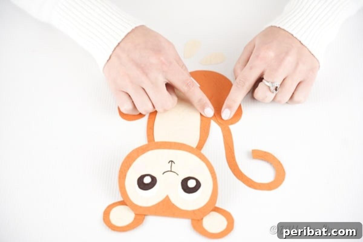 DIY Monkey Card Fun for Kids 18 A paper monkey with its tail being glued onto its back, completing the outline of the craft.