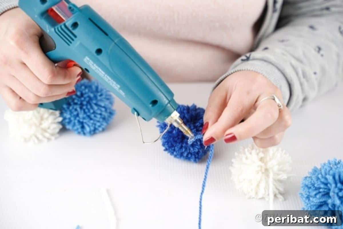 Gluing individual yarn strings to the colorful raindrop pom poms