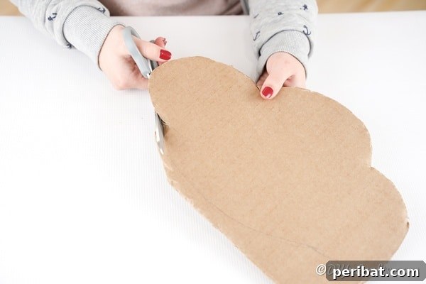 Cutting a cloud shape out of cardboard for the base