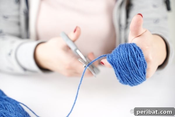 Wrapping yarn around hand to create a pom pom