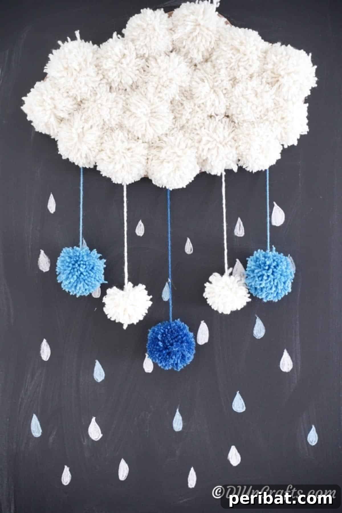 Yarn pom pom cloud art displayed on a chalkboard