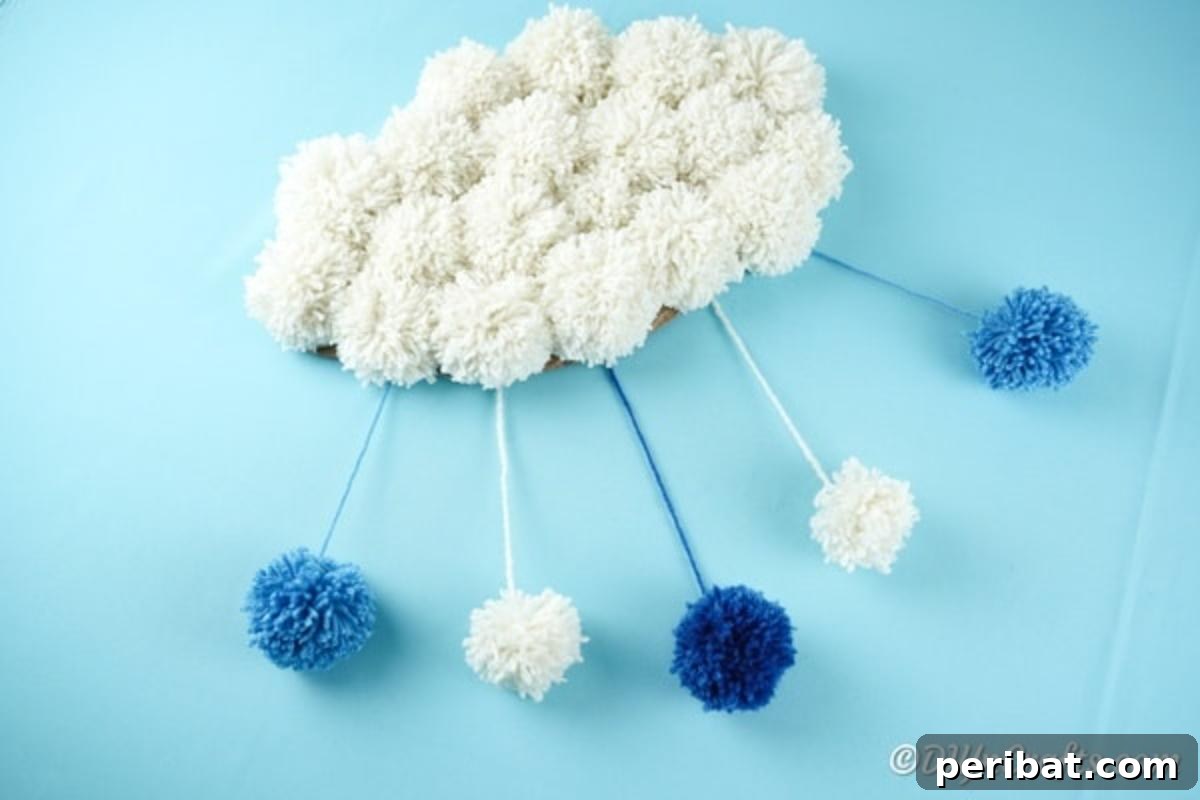 Cloud pom pom craft against a blue background