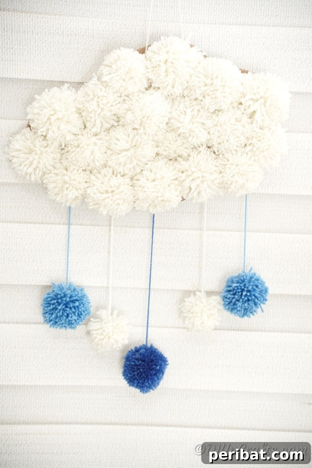Pom pom cloud art displayed against a rustic brick wall