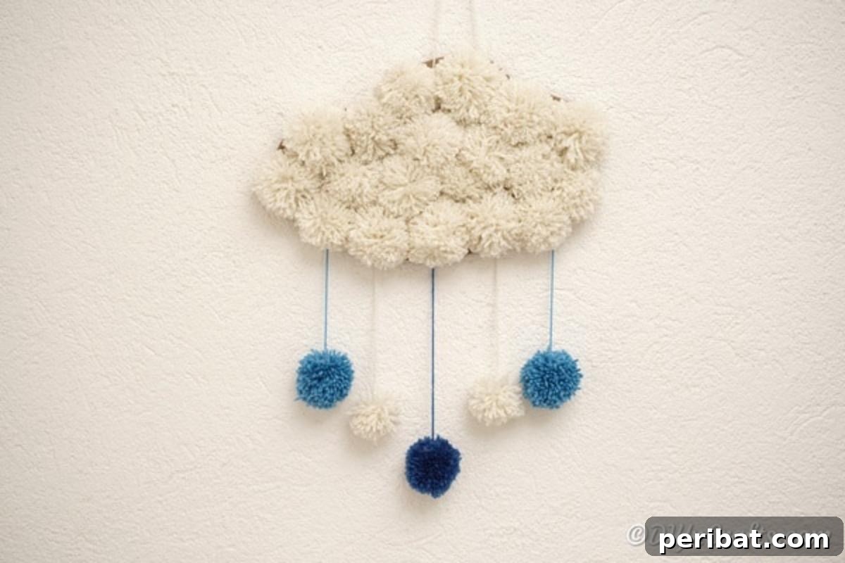 Completed yarn pom pom cloud art on a white wall
