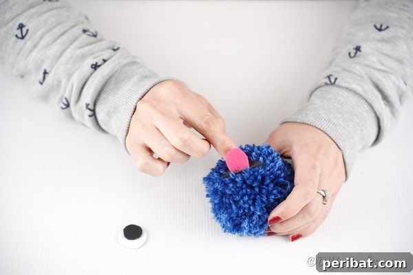 Gluing pink tongue to blue pom pom