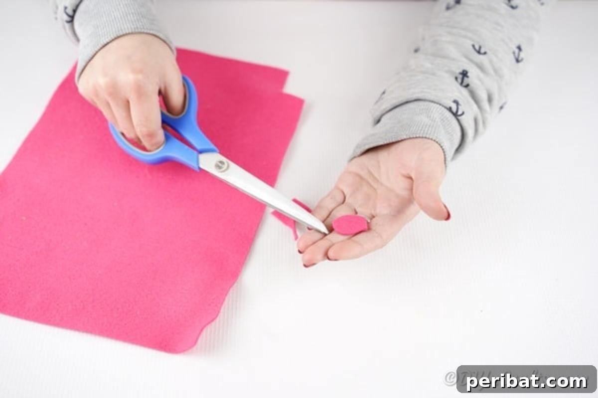 Pink paper being cut into a tongue shape for the monster