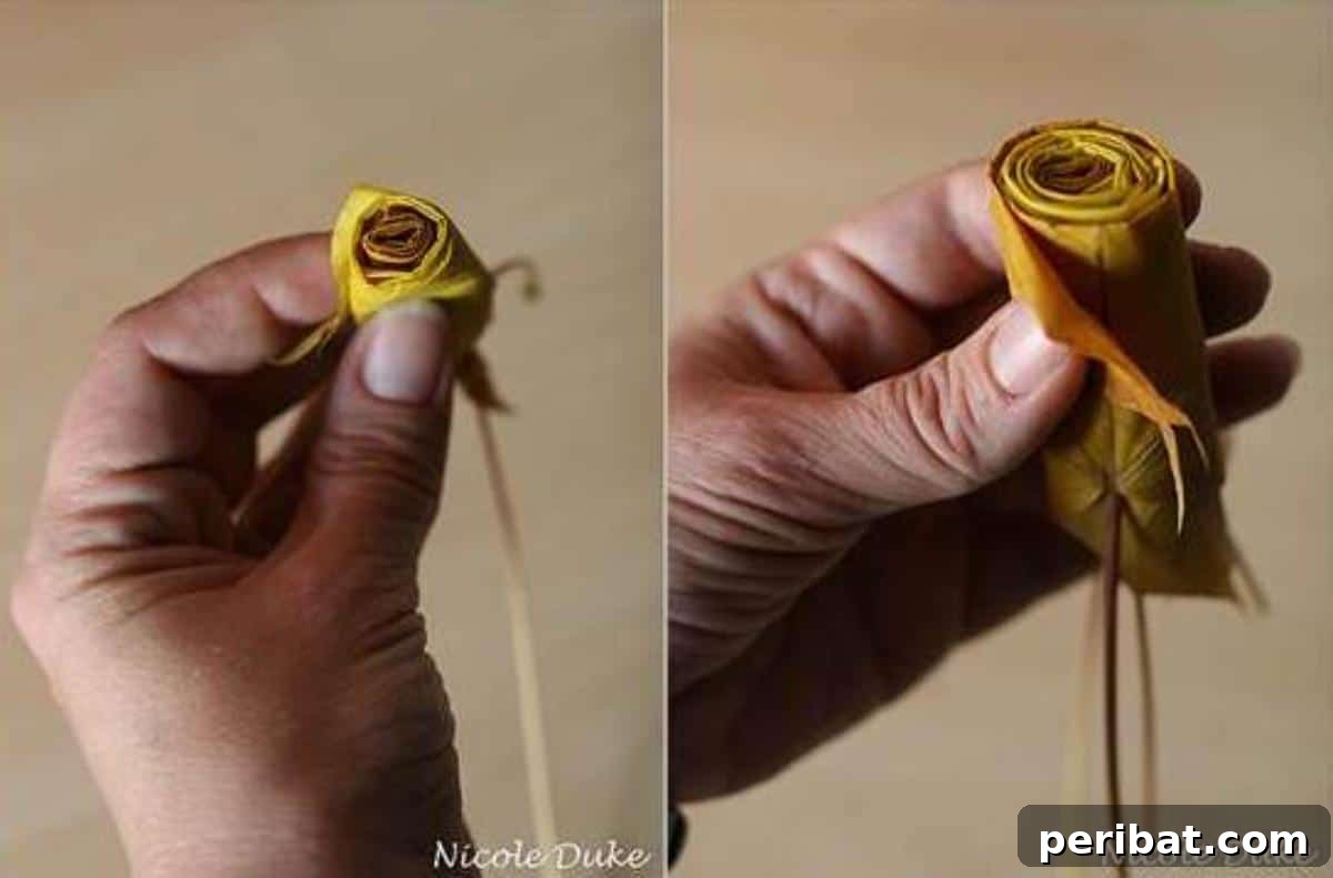Two folded maple leaves wrapped around a central rolled leaf, illustrating the inner petal creation for a DIY leaf rose.