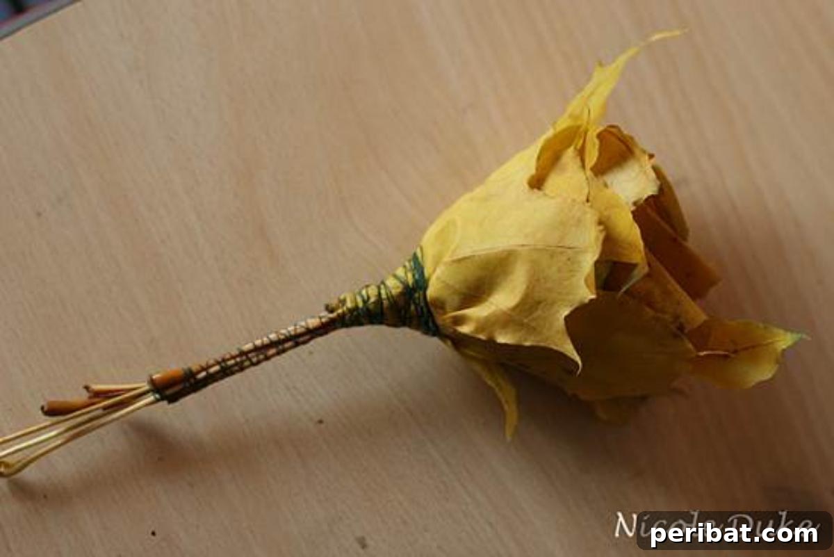 A finished maple leaf rose secured with string around its base, showcasing the single rose stem appearance.